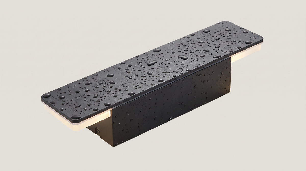 Linea outdoor wall sconce with water droplets beading on its sealed matte black housing