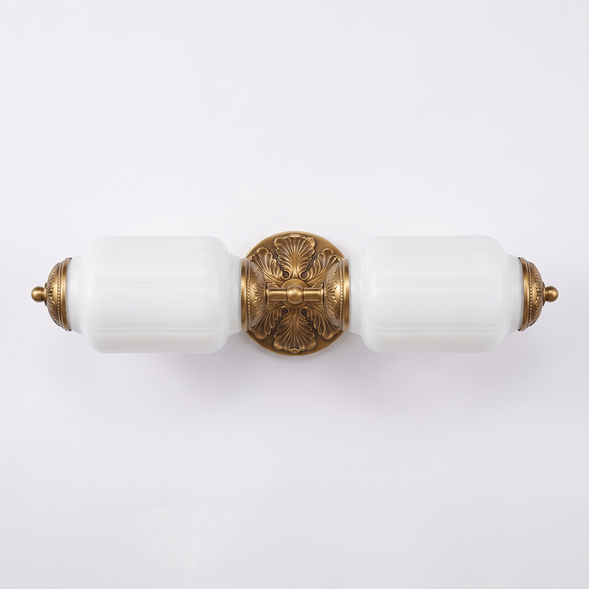 Wren milk glass two light vanity bar with antique brass rosette on a white background