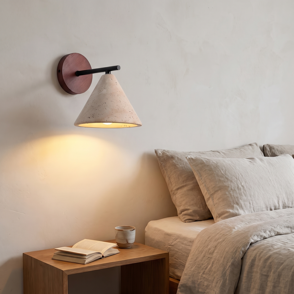 Thea wall sconce lit beside a bed