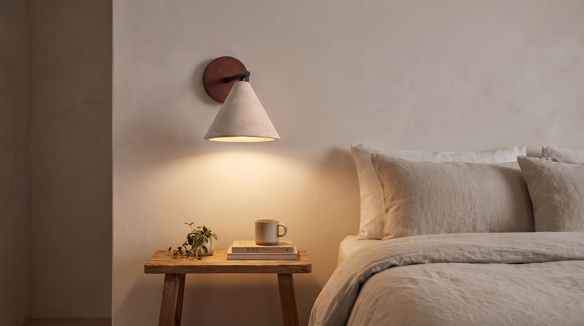 Thea sconce throwing light down onto a bedside table