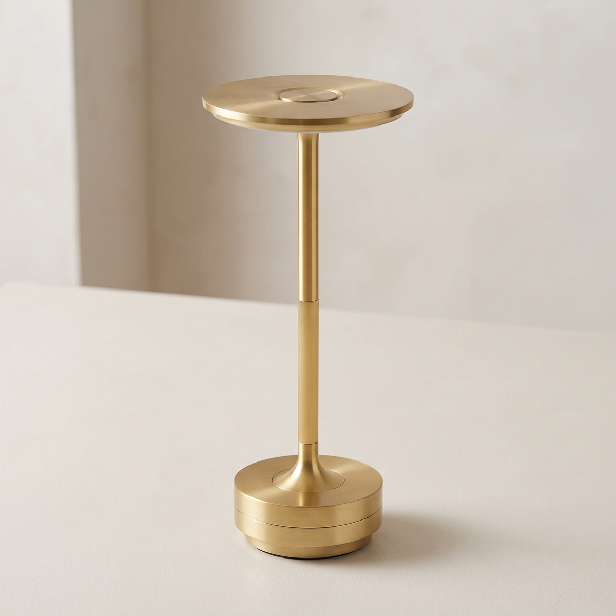 Close view of the brushed gold disc shade and stem of the Vera lamp