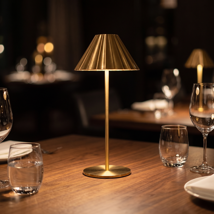 Isla brass cordless lamp lit on a restaurant dining table