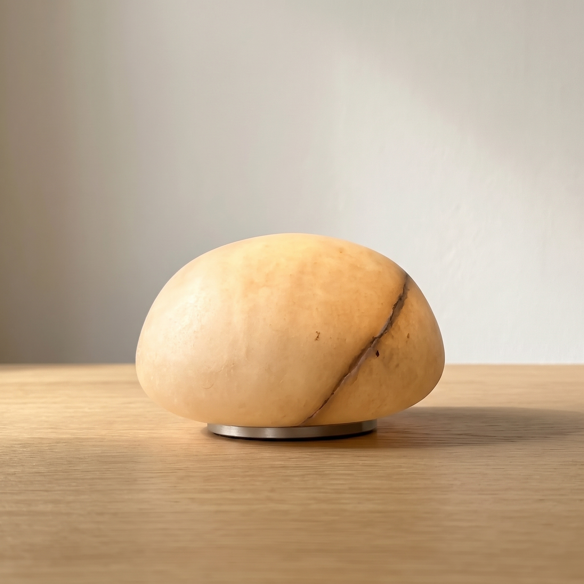 Tove low dome cordless alabaster lamp in honey on an oak table