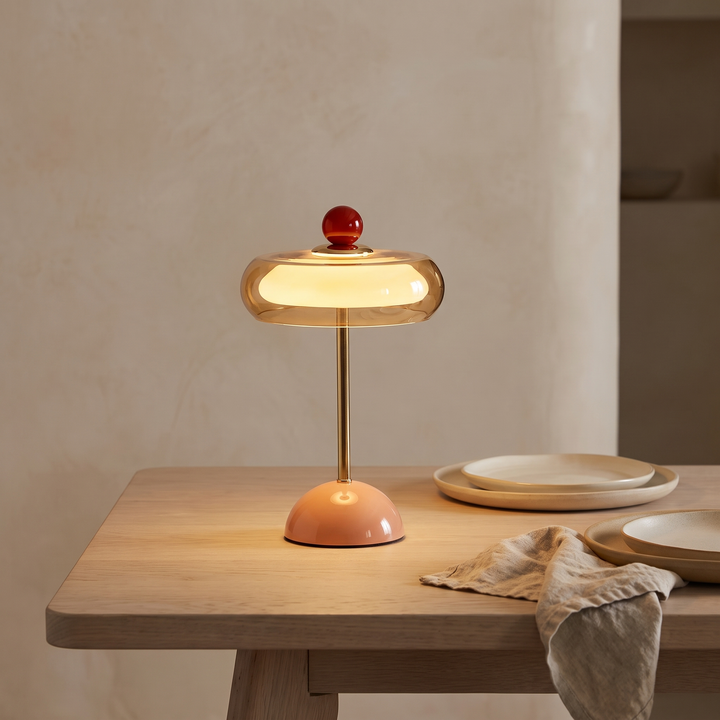 Runa cordless glass disc table lamp lit on an oak dining table