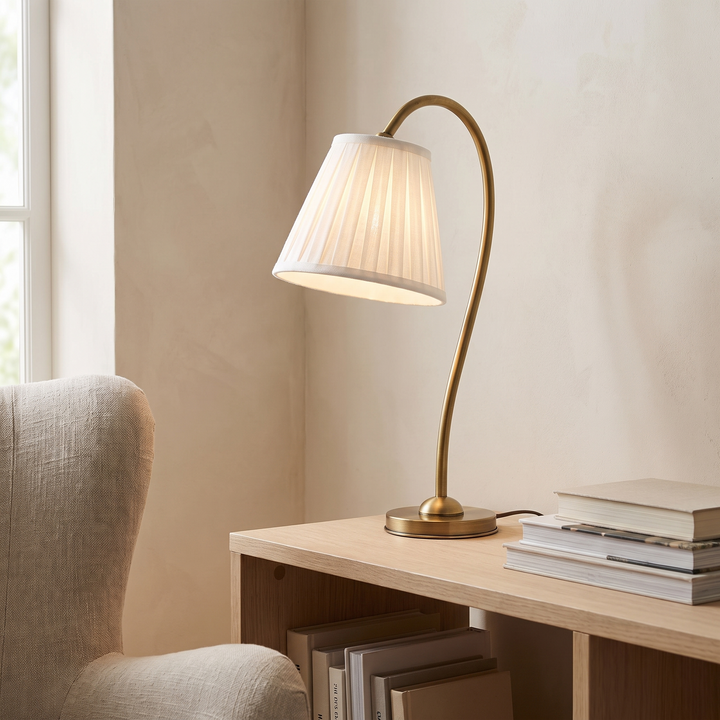 Marit pleated linen shade table lamp lit on an oak console