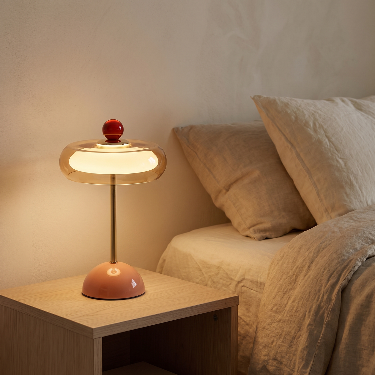 Runa cordless glass disc table lamp lit on an oak bedside table