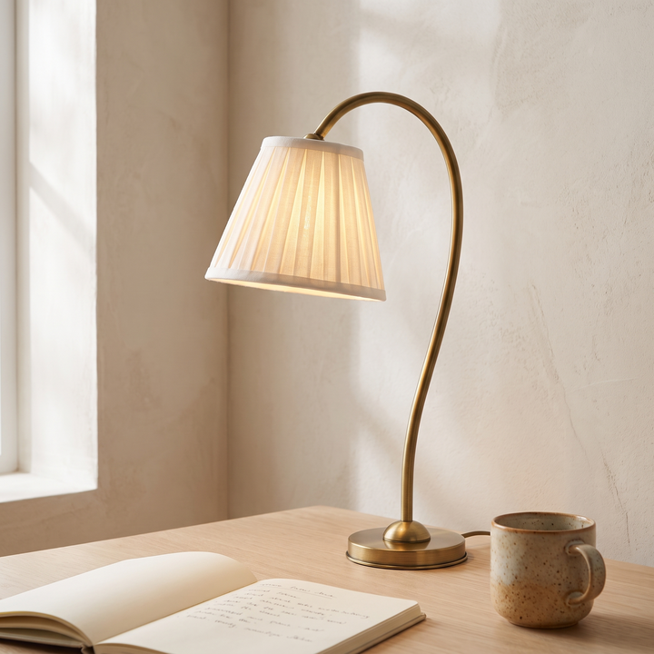 Marit pleated linen table lamp lit on an oak desk