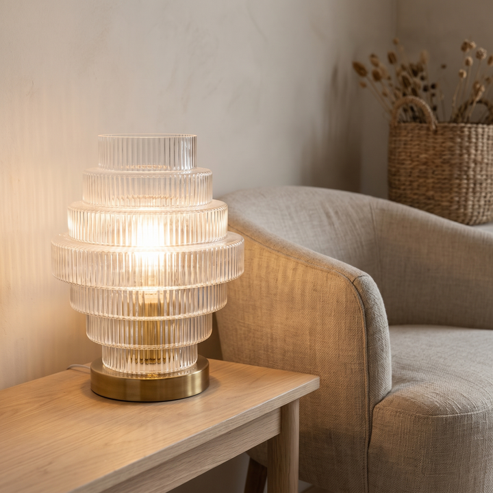 Lova ribbed glass table lamp beside a linen armchair