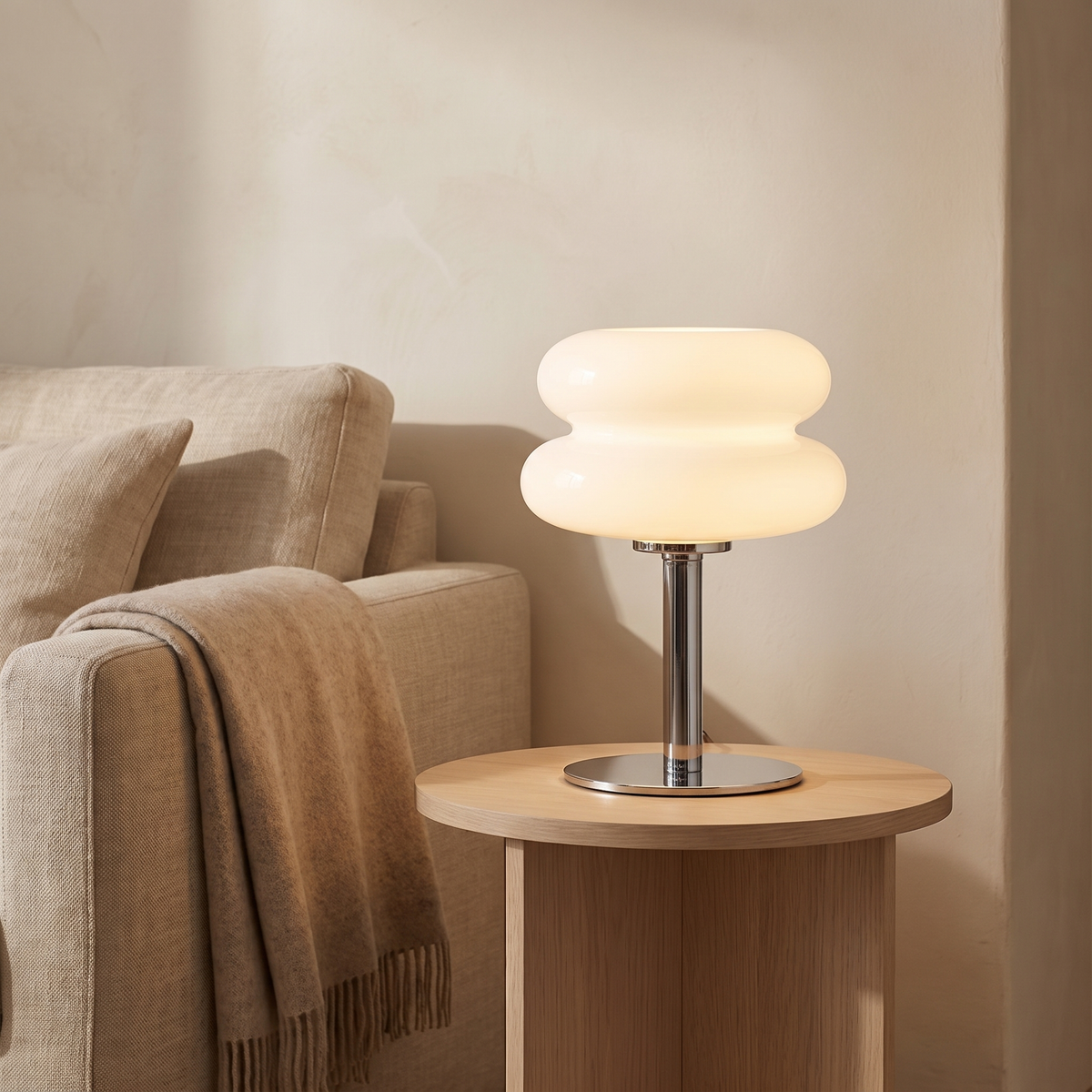 Sylvi glass dome table lamp lit beside a linen sofa
