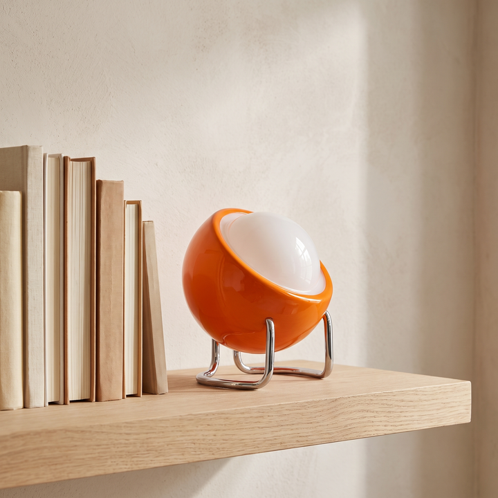 Ines open globe table lamp on an oak shelf with books