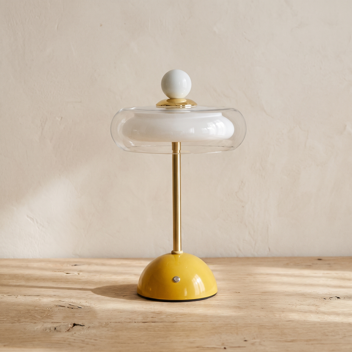 Runa cordless glass disc table lamp with a mustard yellow base
