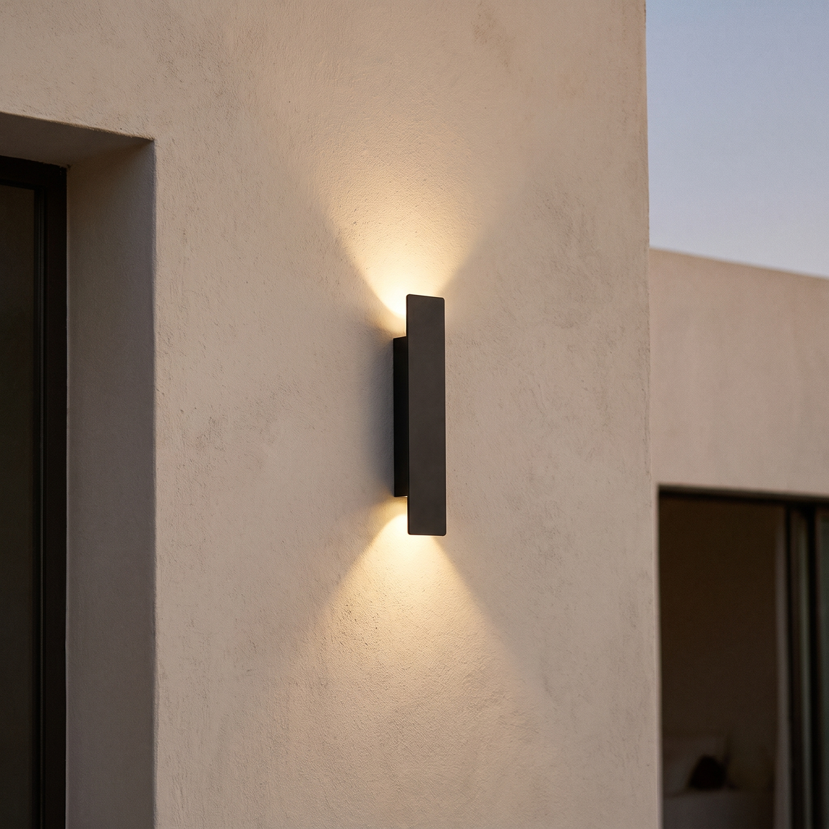 Linea outdoor wall sconce in matte black, 16.1 inch, lighting a plaster wall