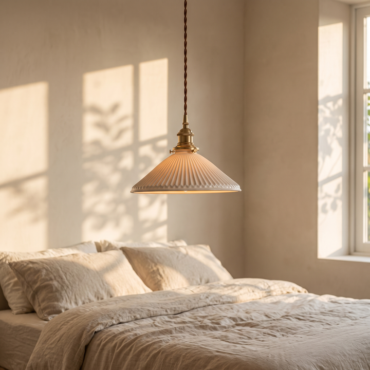 Bellora Cone pendant light above a bed dressed in oatmeal linen