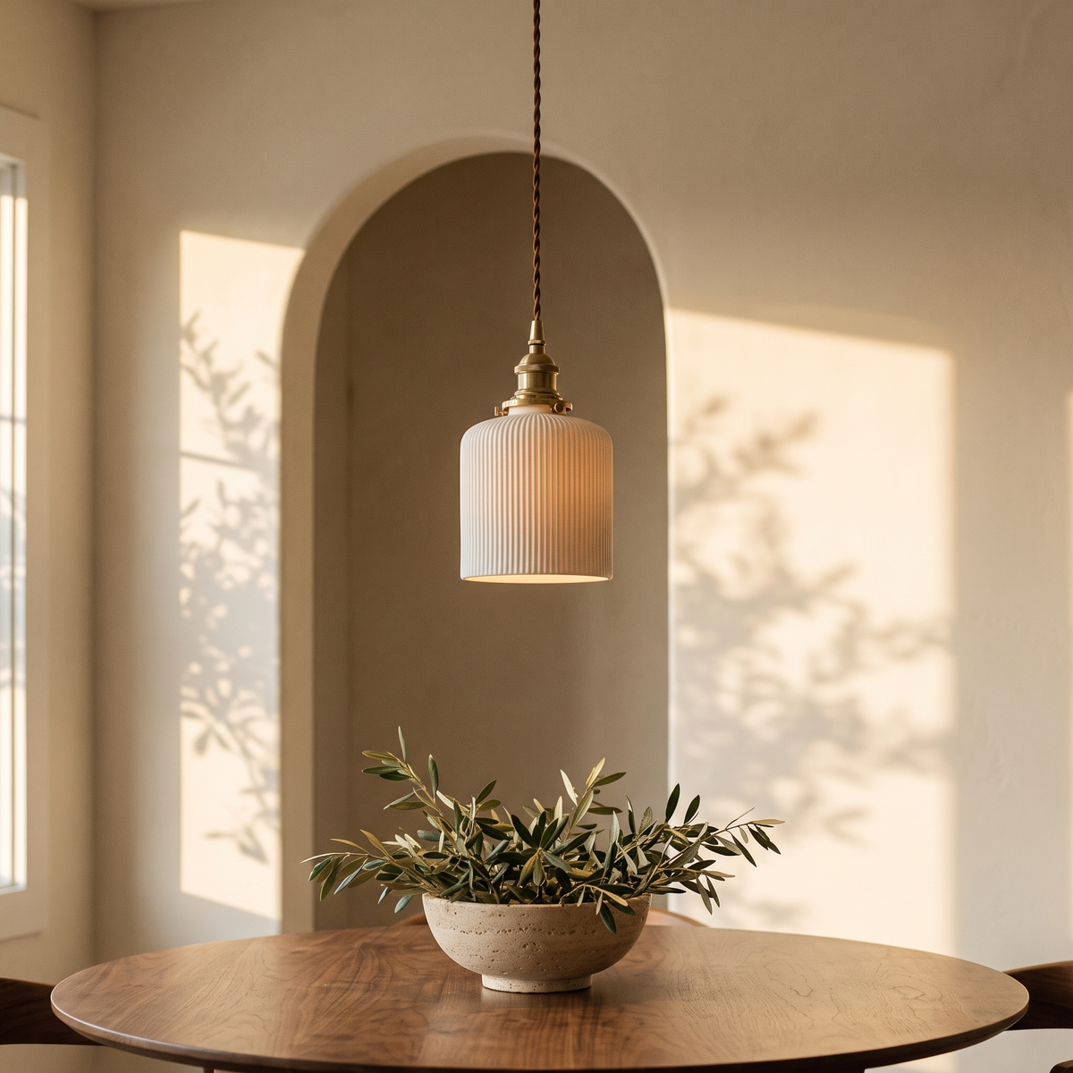 Bellora Cylinder pendant light above a round walnut dining table