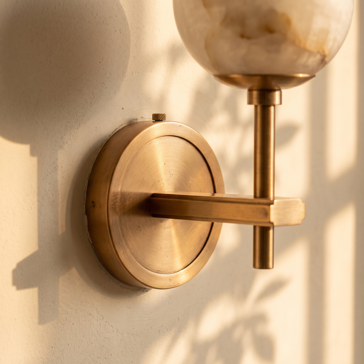 Close detail of the Orbella copper backplate and arm against cream plaster