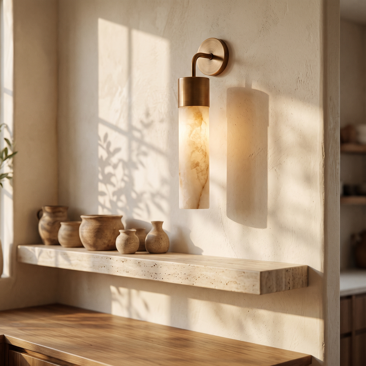 Tessara Long Tube wall sconce above a travertine kitchen shelf with ceramic vessels