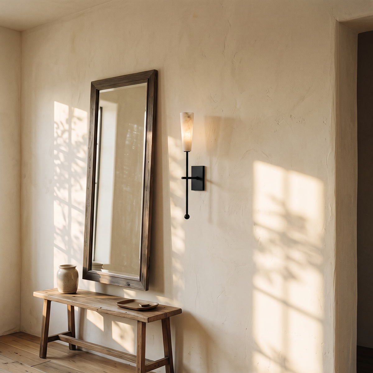 Tessara Torch wall sconce in black mounted beside a mirror