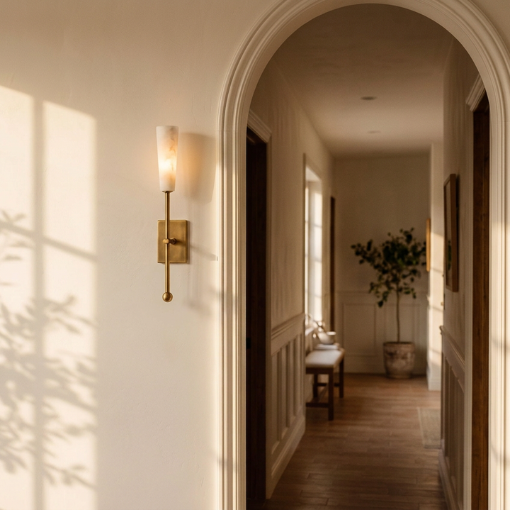 Tessara Torch wall sconce in copper lighting an arched hallway