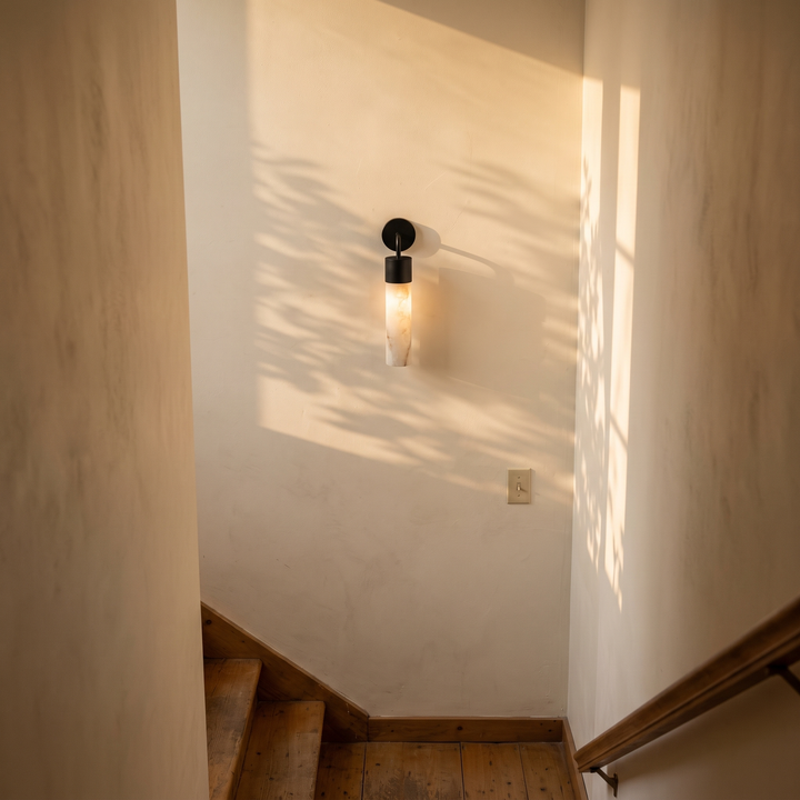 Tessara Long Tube wall sconce in black on a stair passage wall