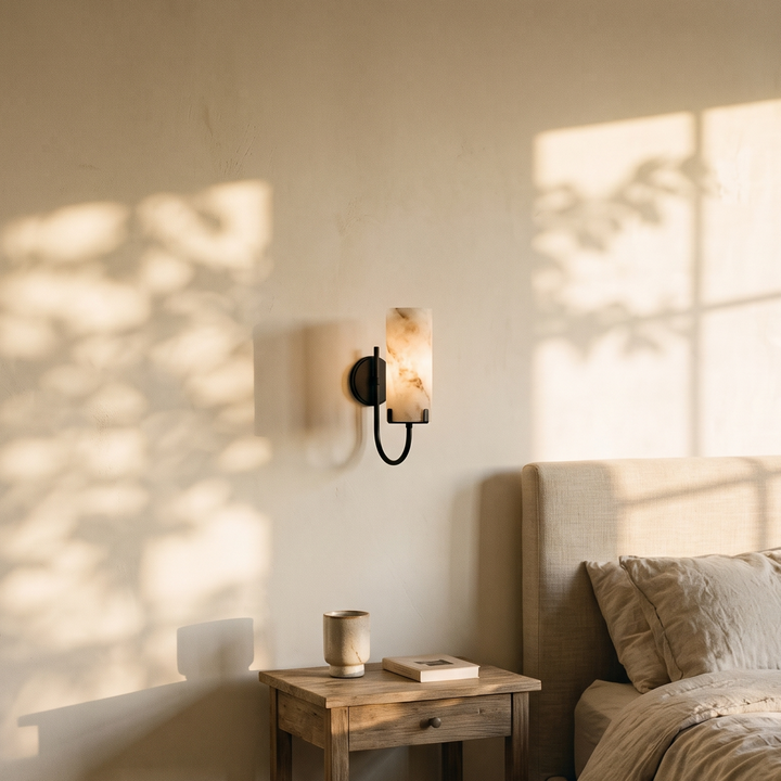 Tessara Loop wall sconce in black beside a bed