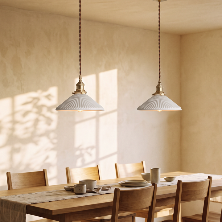 A pair of Bellora Cone pendant lights above a long oak dining table