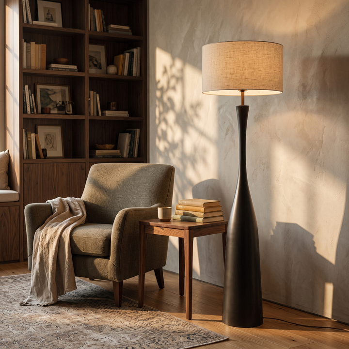 Morella black floor lamp with 17.3 inch shade beside a reading chair
