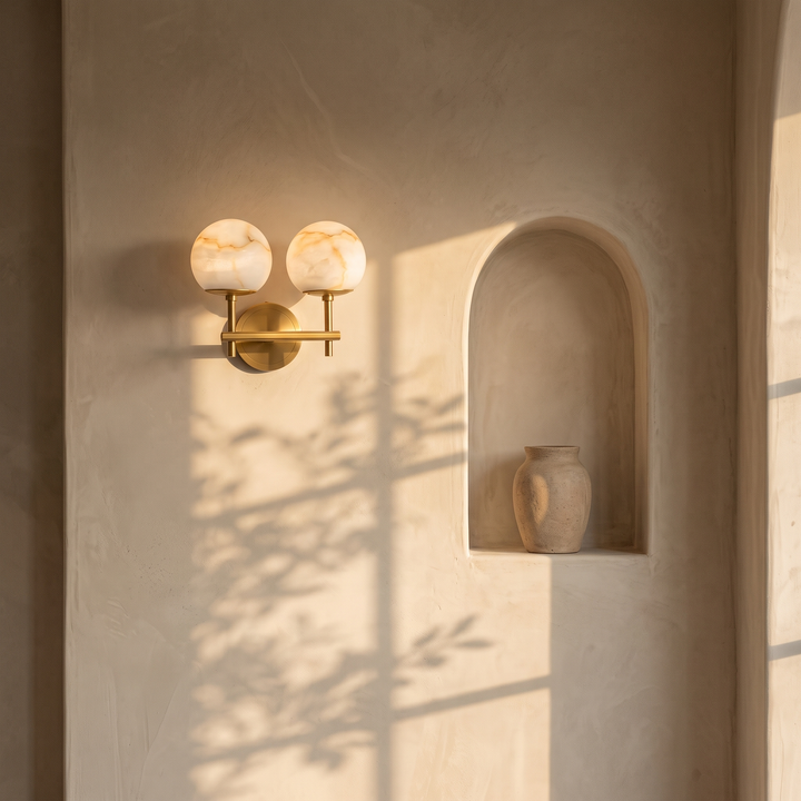Orbella Twin marble sphere wall sconce flanking an arched niche