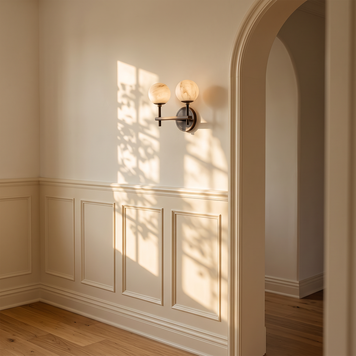 Orbella Twin marble sphere wall sconce on a wainscoted wall