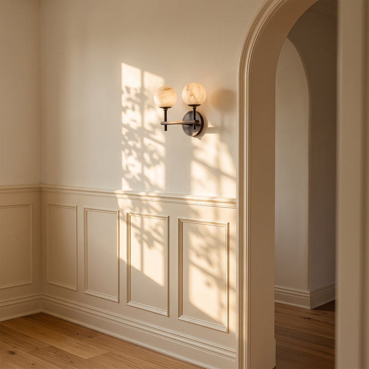 Orbella Twin marble sphere wall sconce on a wainscoted wall