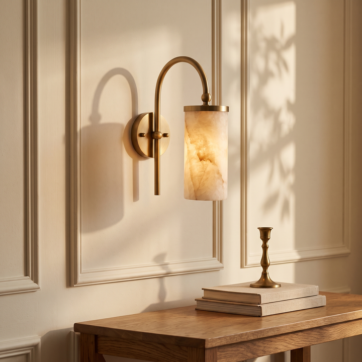 Tessara Arch gooseneck marble wall sconce in copper in an entryway above an oak console