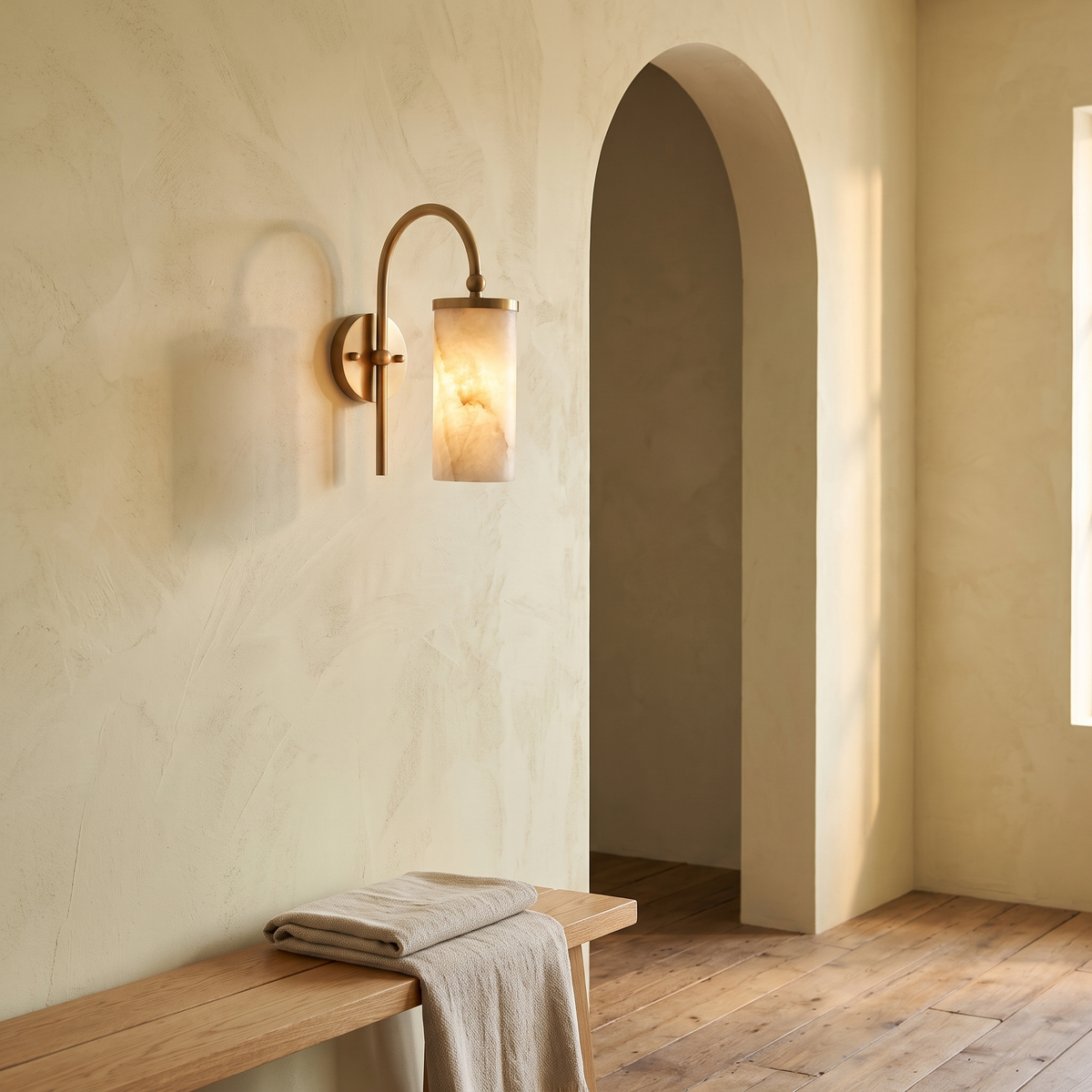 Tessara Arch wall sconce in copper beside an arched doorway above an oak bench