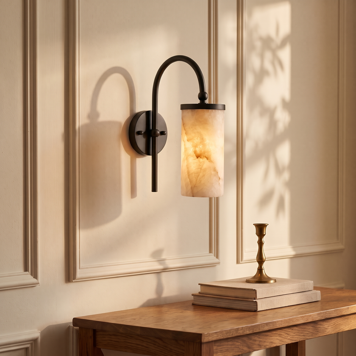 Tessara Arch gooseneck marble wall sconce in matte black, lit above a desk