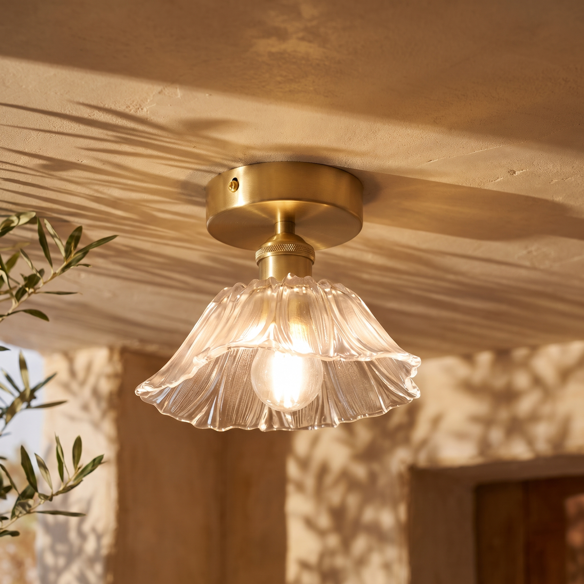 Fiorella flush mount petal glass ceiling light in opal white, lit on a plaster ceiling
