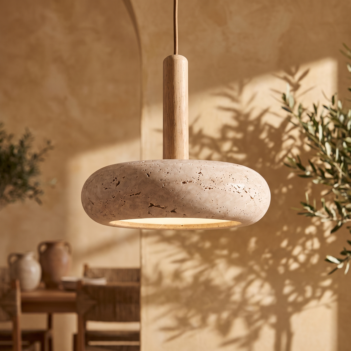 Maeve travertine and walnut LED disc pendant light, lit in a dining room