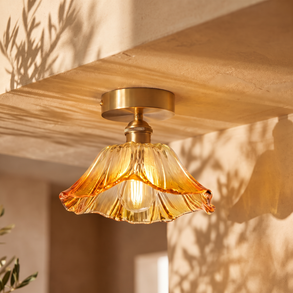 Fiorella flush mount petal glass ceiling light in honey amber, lit on a plaster ceiling in a stairwell landing