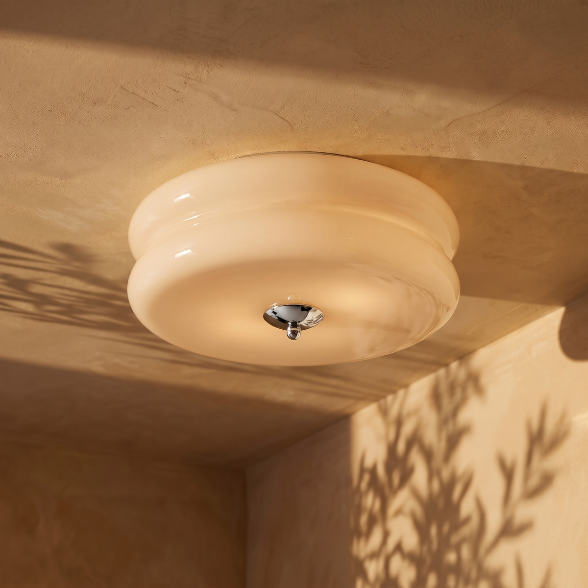 Deliona opal glass flush mount ceiling light in chrome and beige, lit on a plaster ceiling