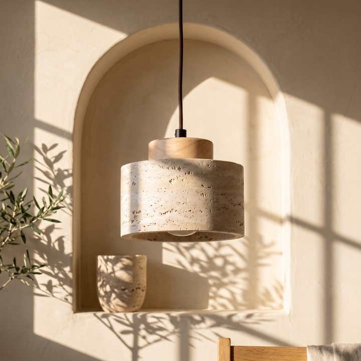 Edda Drum light wood travertine pendant light in front of an arched plaster niche