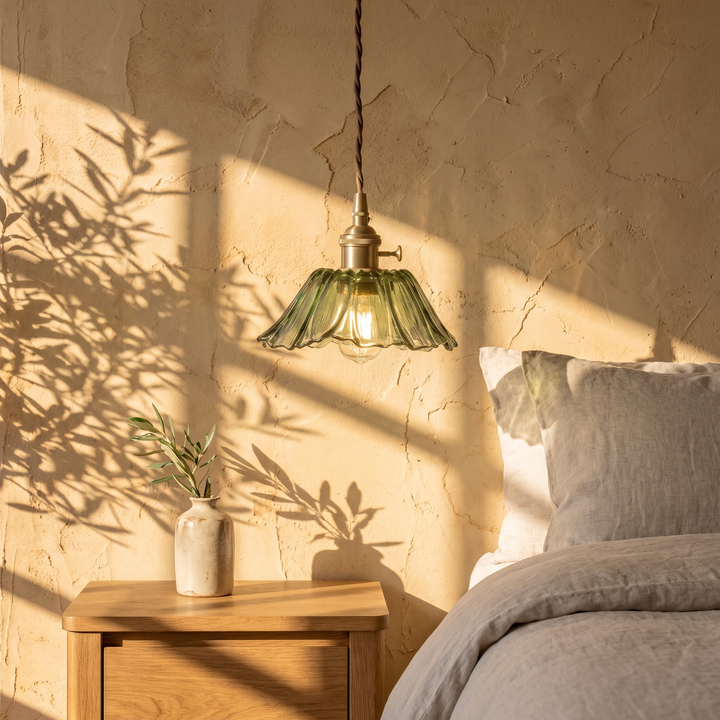 Fiorella petal glass cord pendant light in leaf green beside a linen dressed bed