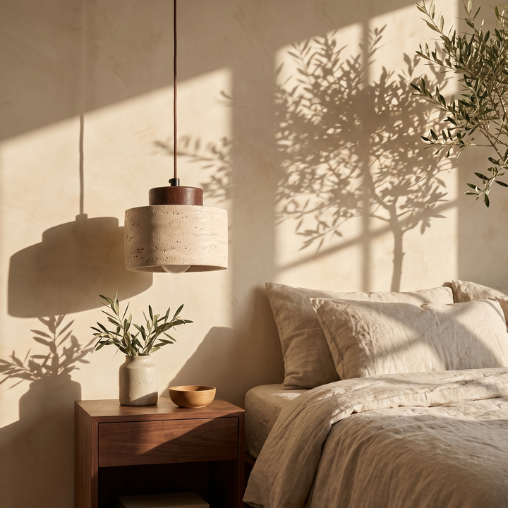 Edda Drum walnut travertine pendant light beside a linen dressed bed